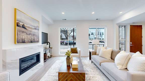 A living room with a fireplace and a painting on the wall.