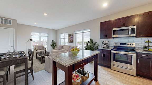 A modern kitchen with dark wood cabinets and stainless steel appliances.
