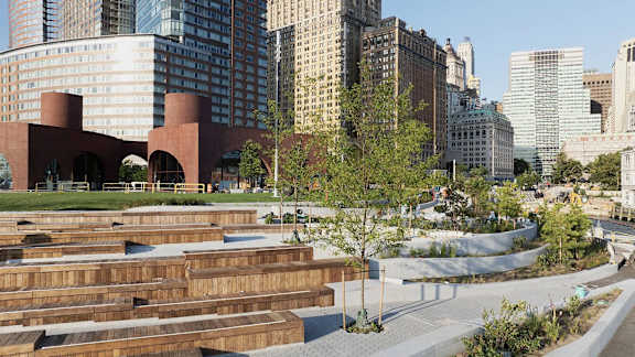 A couple is sitting on the grass by the water.