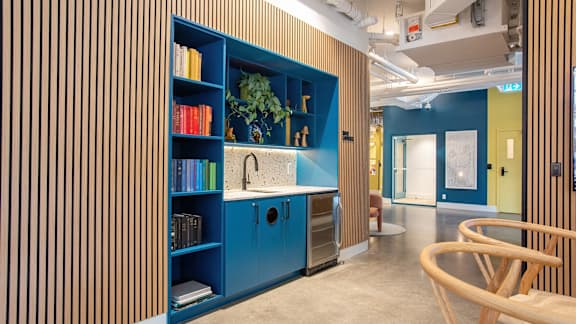 a kitchen with a blue bookshelf and a sink in a lobby