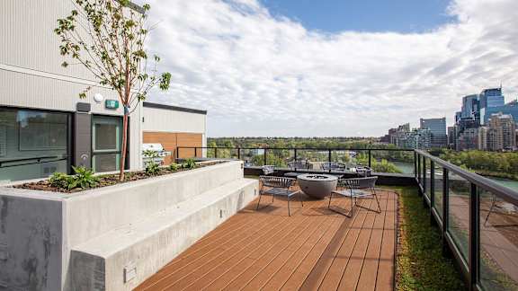 a roof terrace with a city skyline in the background and a deck with furniture