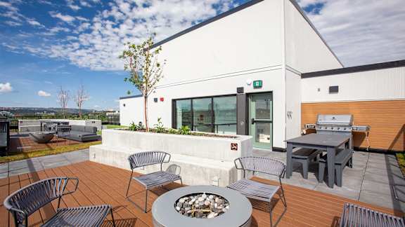 a patio with tables and chairs and a fire pit
