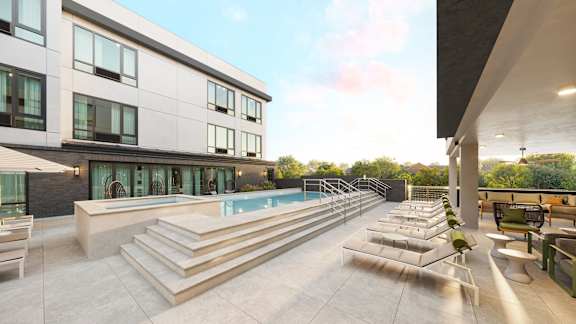 A modern house with a pool and lounge chairs.