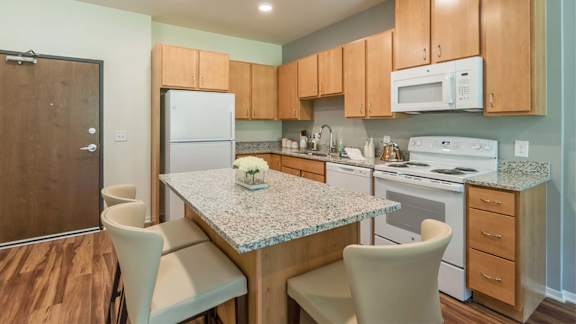 a kitchen with a granite counter top and white appliances