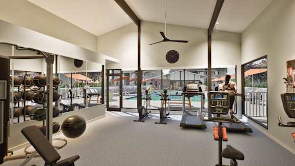 a gym with weights and cardio equipment and a pool in the background