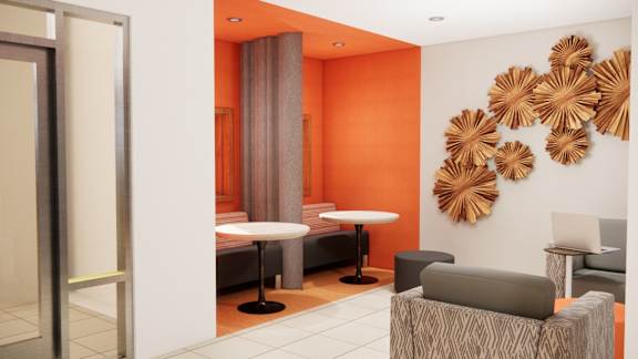 A room with orange walls and a white table with a laptop on it.