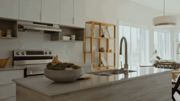 A modern kitchen with a bowl of vegetables on the counter.