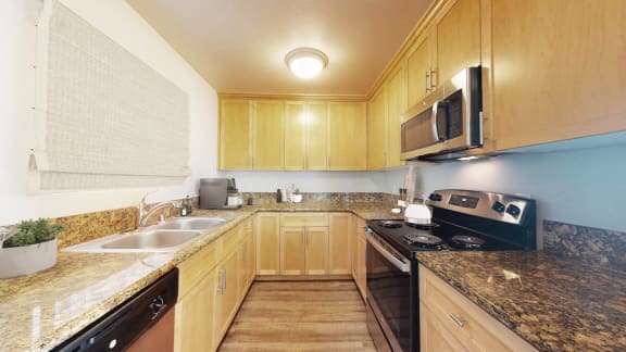 a kitchen with granite counter tops and wooden cabinets at Marina Harbor, Marina del Rey, CA, 90292