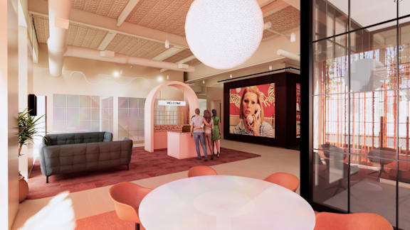 A modern living room with a couch, a coffee table, and a large poster on the wall. at University Commons in Pittsburgh, PA