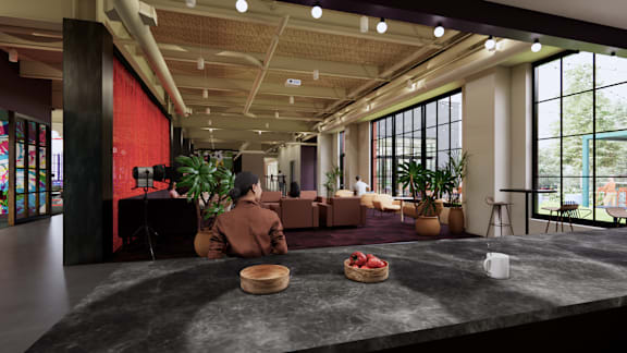 A person is sitting on the floor in a room with a large window. at University Commons in Pittsburgh, PA