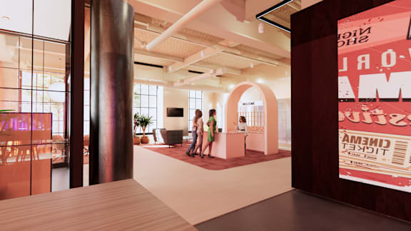 A modern office space with a reception desk and two people standing by it. at University Commons in Pittsburgh, PA