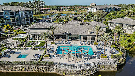 a mansion with a swimming pool and patio furniture on the water