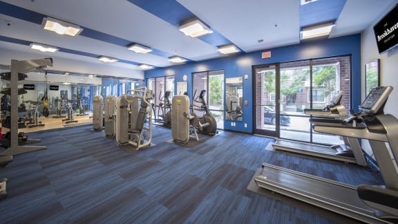 a gym with cardio equipment and a glass door at The Haven, Atlanta, 30329