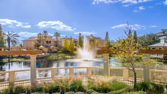 a fountain in the middle of a pond at the resort