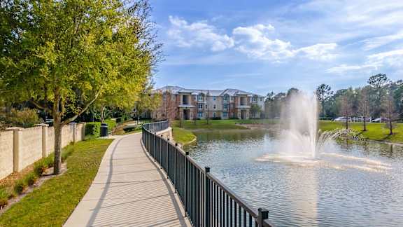 A fountain in the middle of a lake in a park.