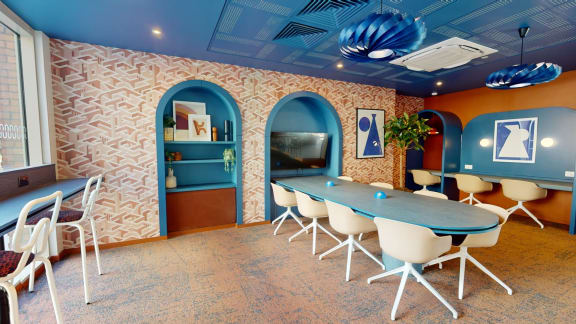 a conference room with a table and chairs and a television