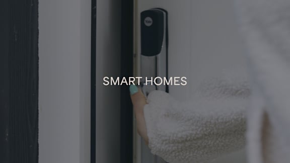 A smart home security camera is mounted on a wall.