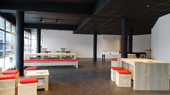 A room with a lot of furniture and a white wall.