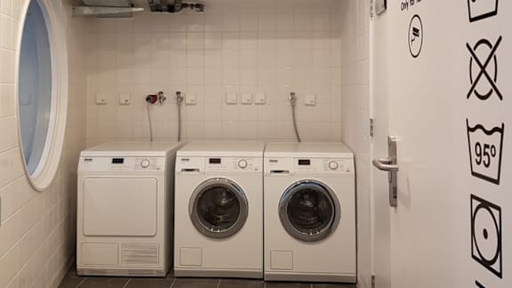 Two front loading washing machines in a small laundry room.