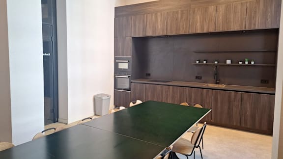 A black table is in front of a wooden cabinet.
