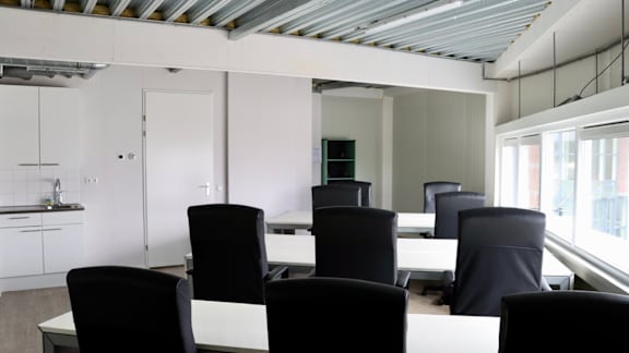 A conference room with black chairs and a white table.