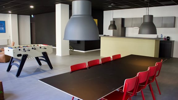 A room with a pool table, a bar, and a billiards table.