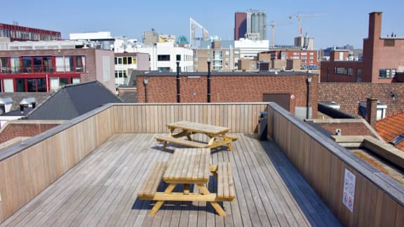 A wooden deck with two picnic tables on it.