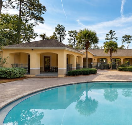 A large house with a pool in front.