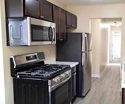 a kitchen with a stove and refrigerator and a sink