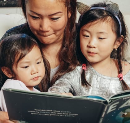 A woman and young children looking at a book