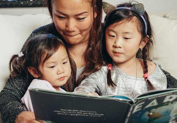 A woman and young children looking at a book