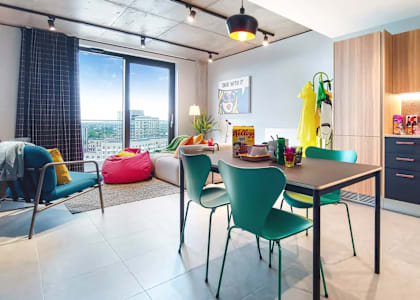 A modern kitchen with a dining table and chairs at Beton Apartments, Wembley, HA9 0SL