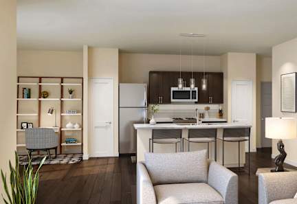 A modern living room with a kitchen in the background.