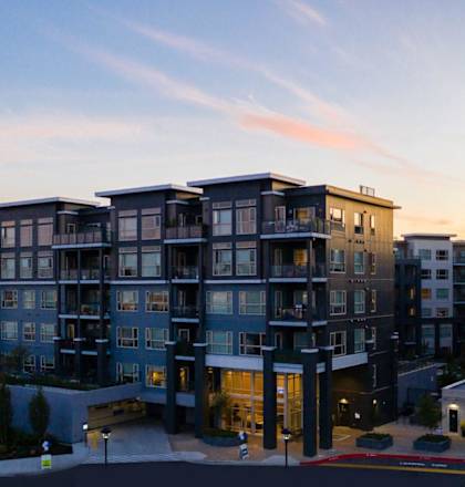 a rendering of a large apartment building at sunset