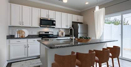 a kitchen with white cabinets and a granite counter top