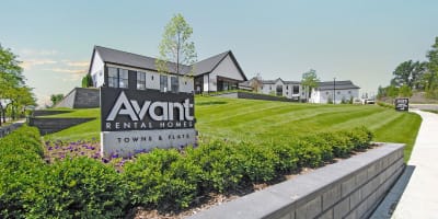 a view of the avanti rental homes sign in front of a grassy yard
