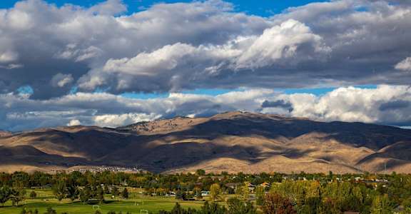A landscape with mountains and clouds in the sky.