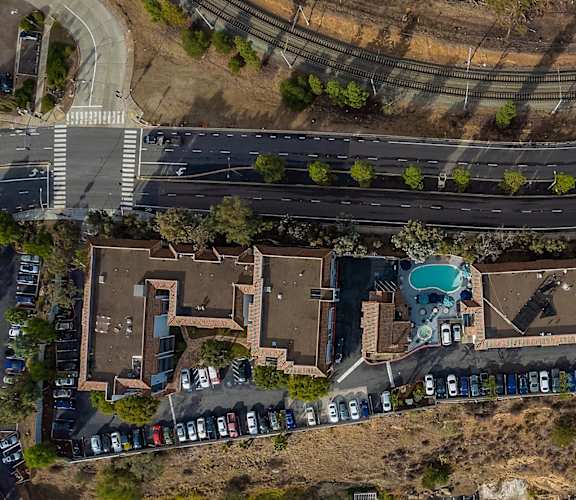 A bird's eye view of a residential area with houses and parked cars.