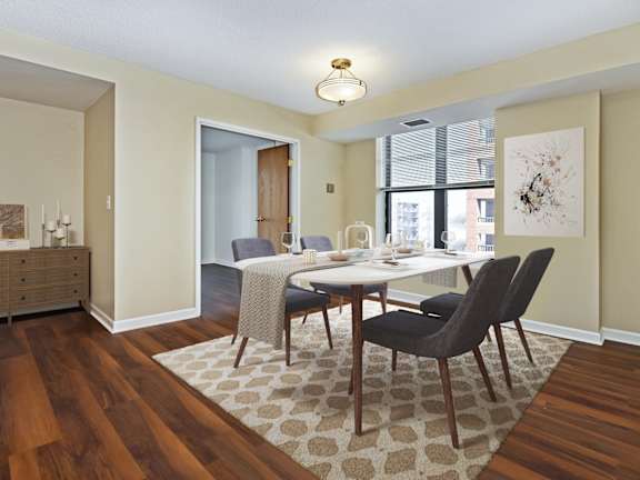 A living room with a grey couch, a coffee table, and a bar area in the background.