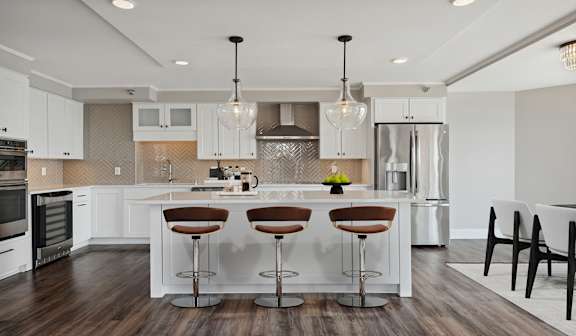A modern kitchen with white cabinets and a center island.