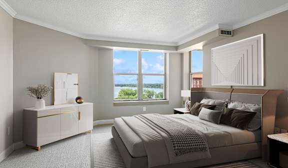 A bedroom with a large bed and a dresser with a mirror.