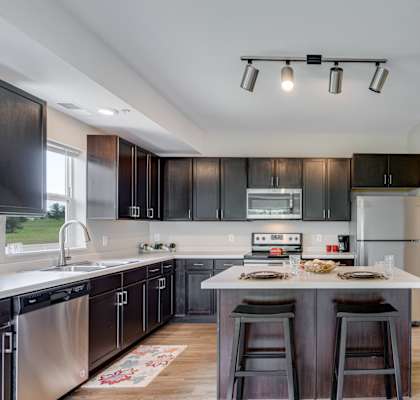 Large Kitchen Featuring Spacious Island With Barstool Seating
