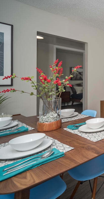 an open living room and dining room with a blue couch and a wooden table