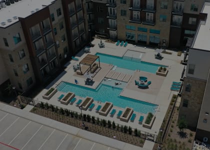 A pool surrounded by buildings and trees.