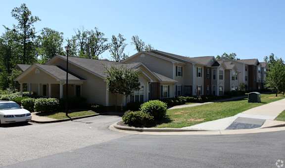A white car is parked in front of a house.