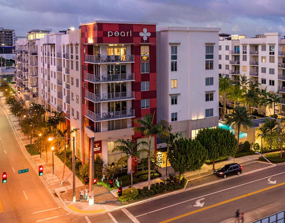 A street view of a Pearl apartment building at dusk.