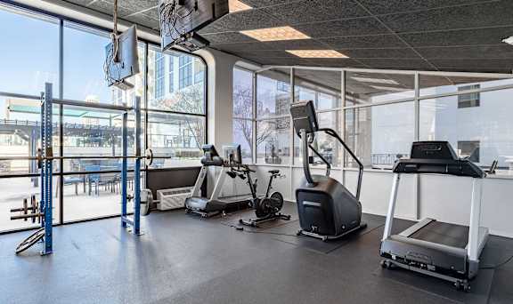 A gym with treadmills, elliptical machines, and other exercise equipment.