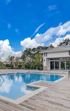 A swimming pool surrounded by a wooden deck and trees.