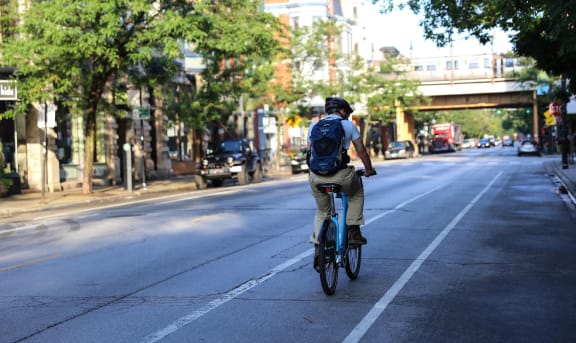 a man riding a bike down a street at 1033 W Loyola, Illinois