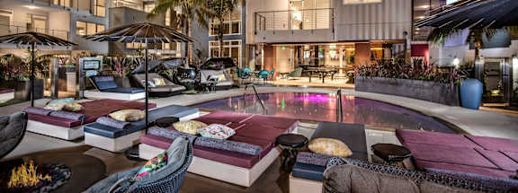 Vinz on Fairfax Apartments in Los Angeles, California Exterior and Pool with Lounge Chairs at Dusk
